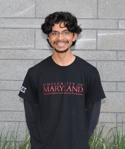 Photo of Aarav Verma standing in front of a gray brick wall