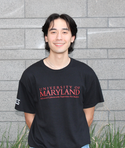 Photo of Max Jih-Vieira in front of a gray brick wall