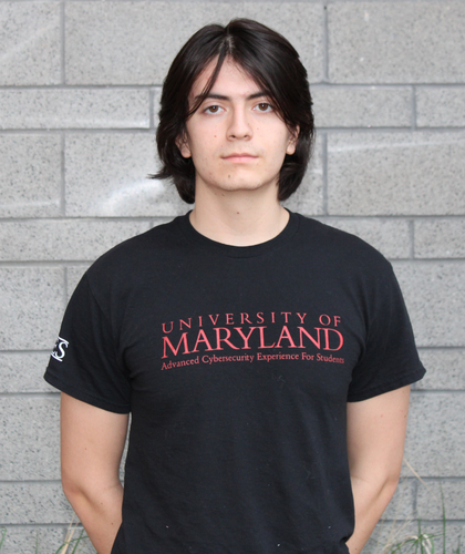 Photo of Sebastian Acevedo standing in front of a gray brick wall